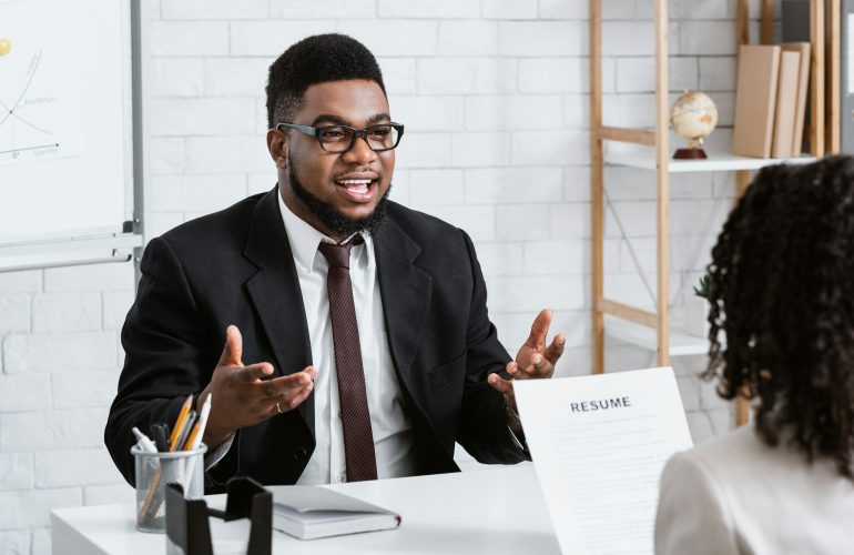 Human resources manager communicating with positive vacancy applicant on employment interview at